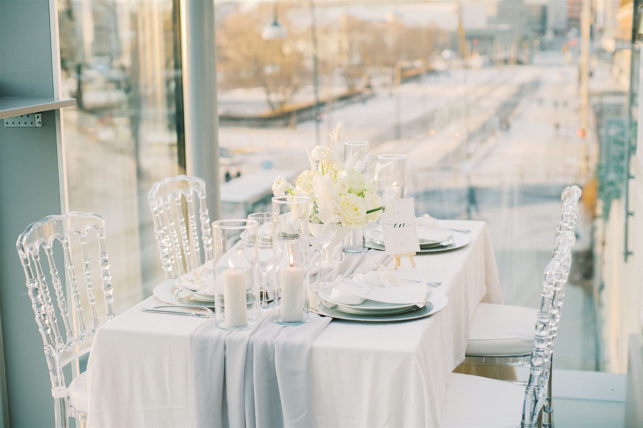Vinterbord til bryllupet med vintersolen i bakgrunnen over Rådhusplassen. Dekketallerken i sølv med moderne trykksaker.