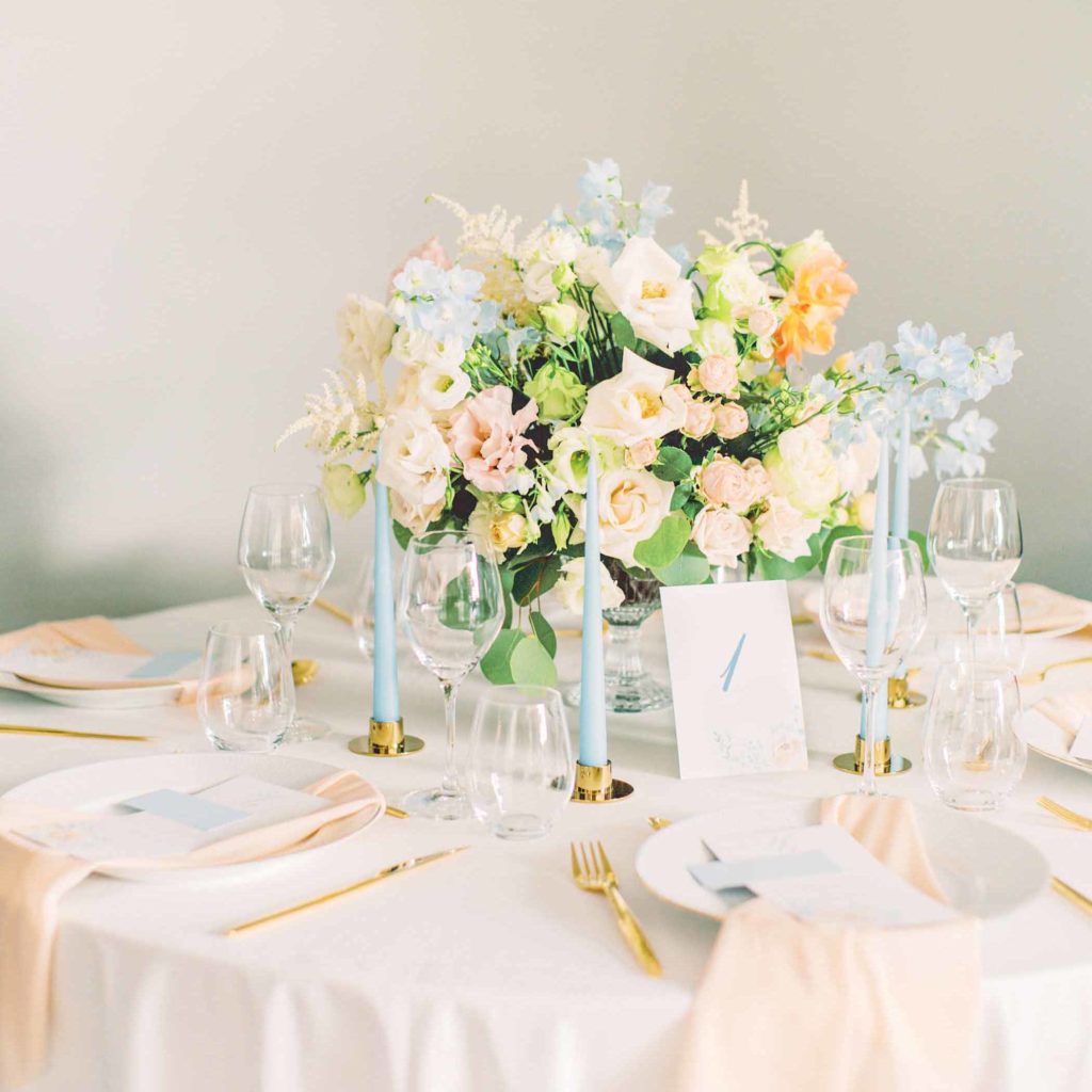Bryllupsbord i lyseblå og fersken, med varm sommerlig bukett i mange farger. Trykksaker i lyseblå og fersken med fersken servietter og gullbestikk.