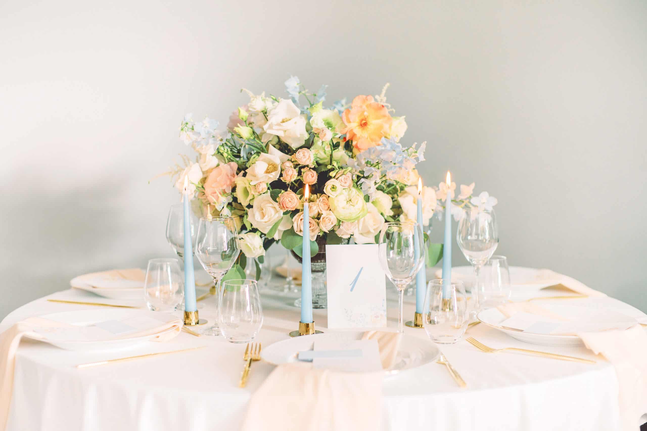 bryllupsbord med blomsterbukett i fersken og lyseblå